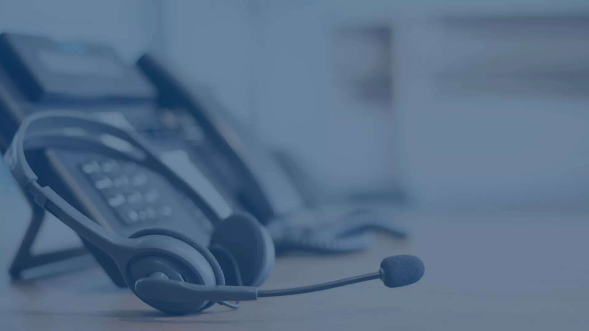 Telefonapparat mit Headset auf einem Tisch, welche Effizienz im IT-Service Desk symbolisieren