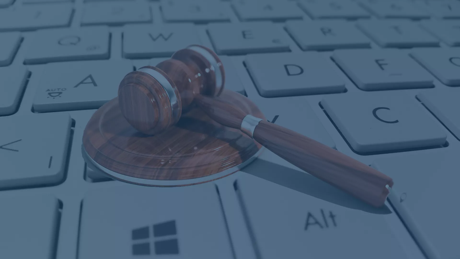 Ein Holzrichterhammer auf einer Computertastatur. Symbolisch für die rechtliche und digitale Verantwortung im Datenschutz gemäß der Datenschutz-Grundverordnung (DS-GVO), die Grundsätze wie Rechtmäßigkeit, Transparenz, Zweckbindung, Datenminimierung, Richtigkeit, Speicherbegrenzung, Integrität, Vertraulichkeit und Rechenschaftspflicht umfasst.