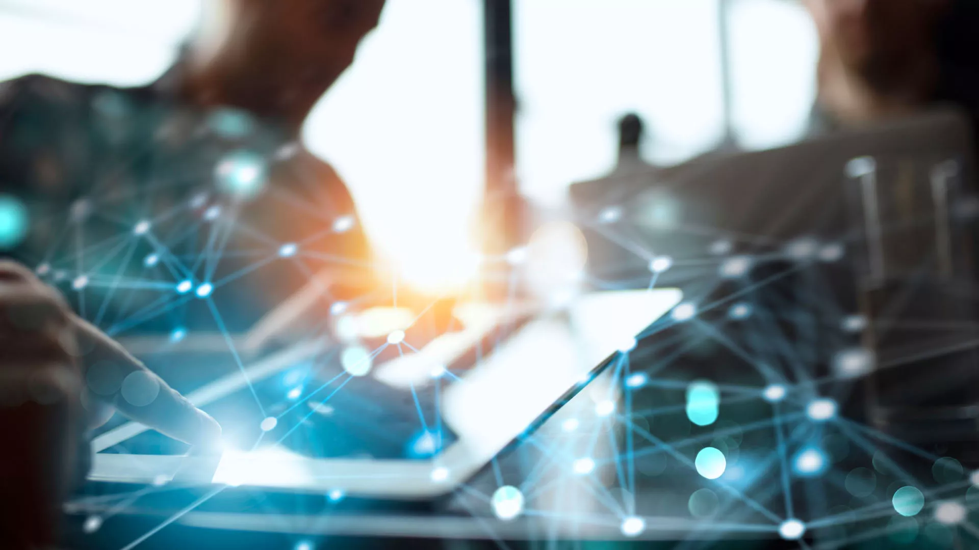 Digitale Netzwerkverbindungen überlagern die Nahaufnahme einer Hand, die ein Tablet bedient, symbolisch für moderne IT-Technologie und Vernetzung.