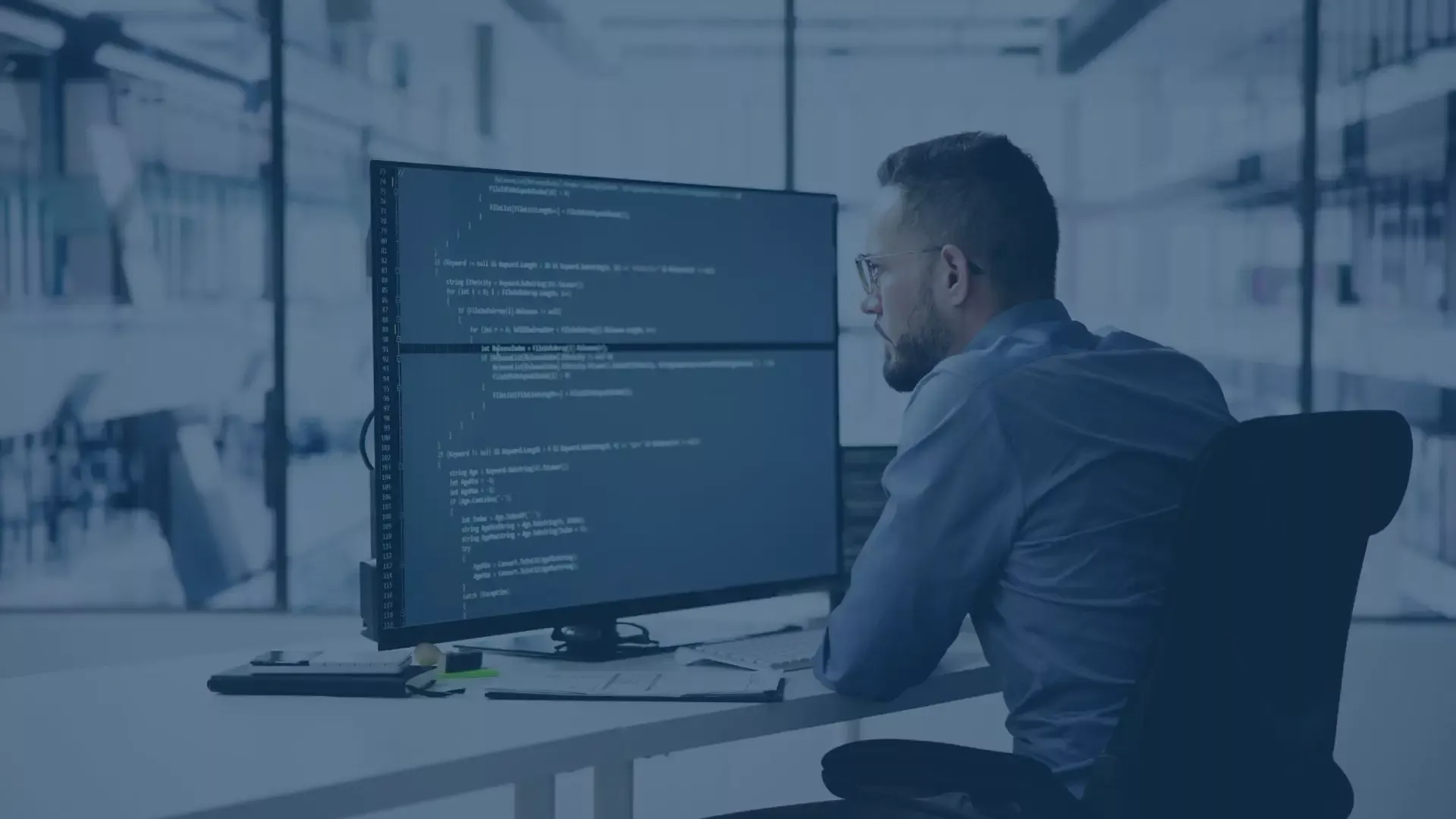 Entwickler vor großem Code-Monitor. Professionelle Implementierung und Einrichtung der audius SEPA-Schnittstelle in Dynamics Business Central.