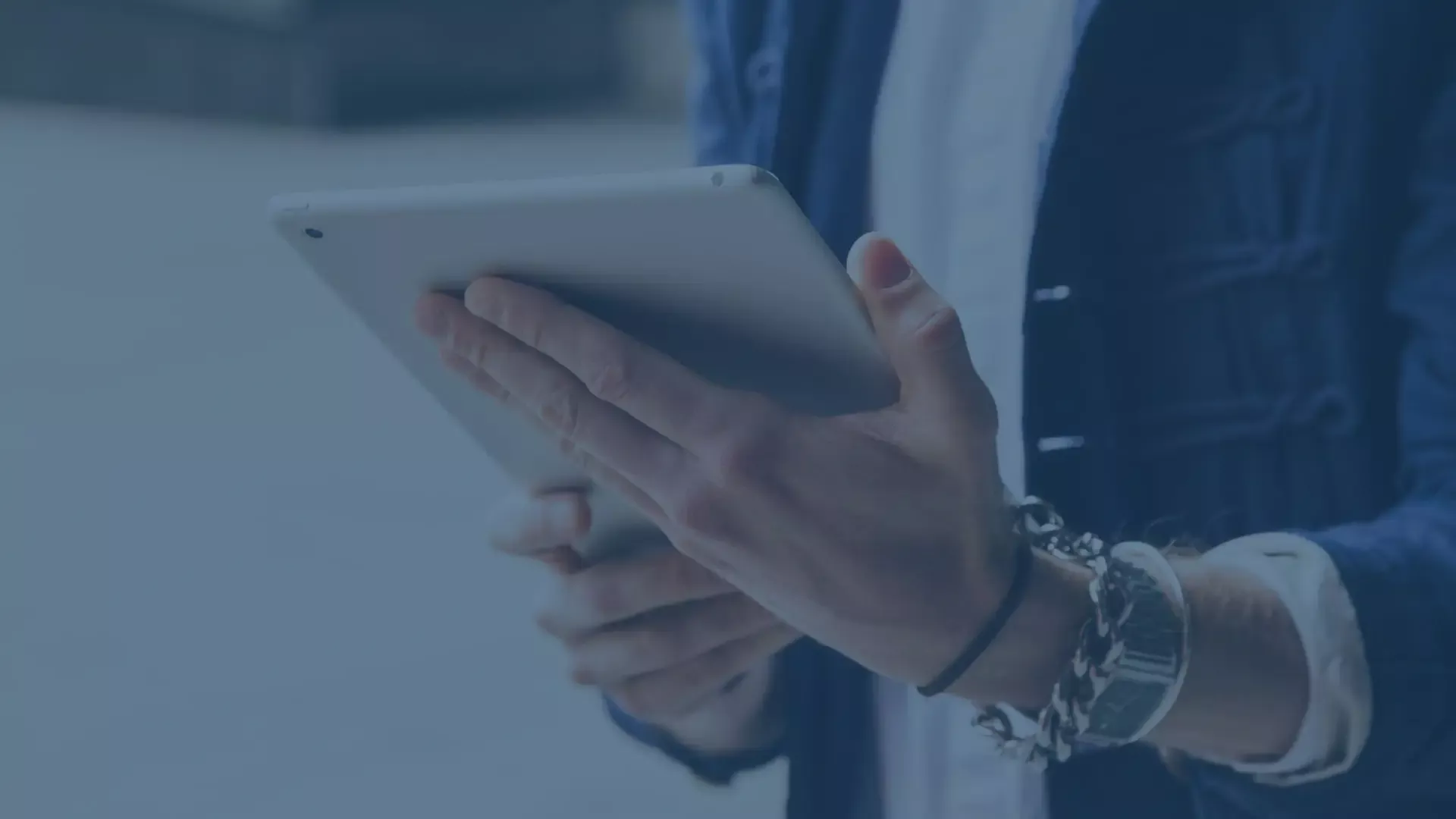 Hände halten ein Tablet, um Mobile Device Management und Enterprise Mobility Management zu veranschaulichen.